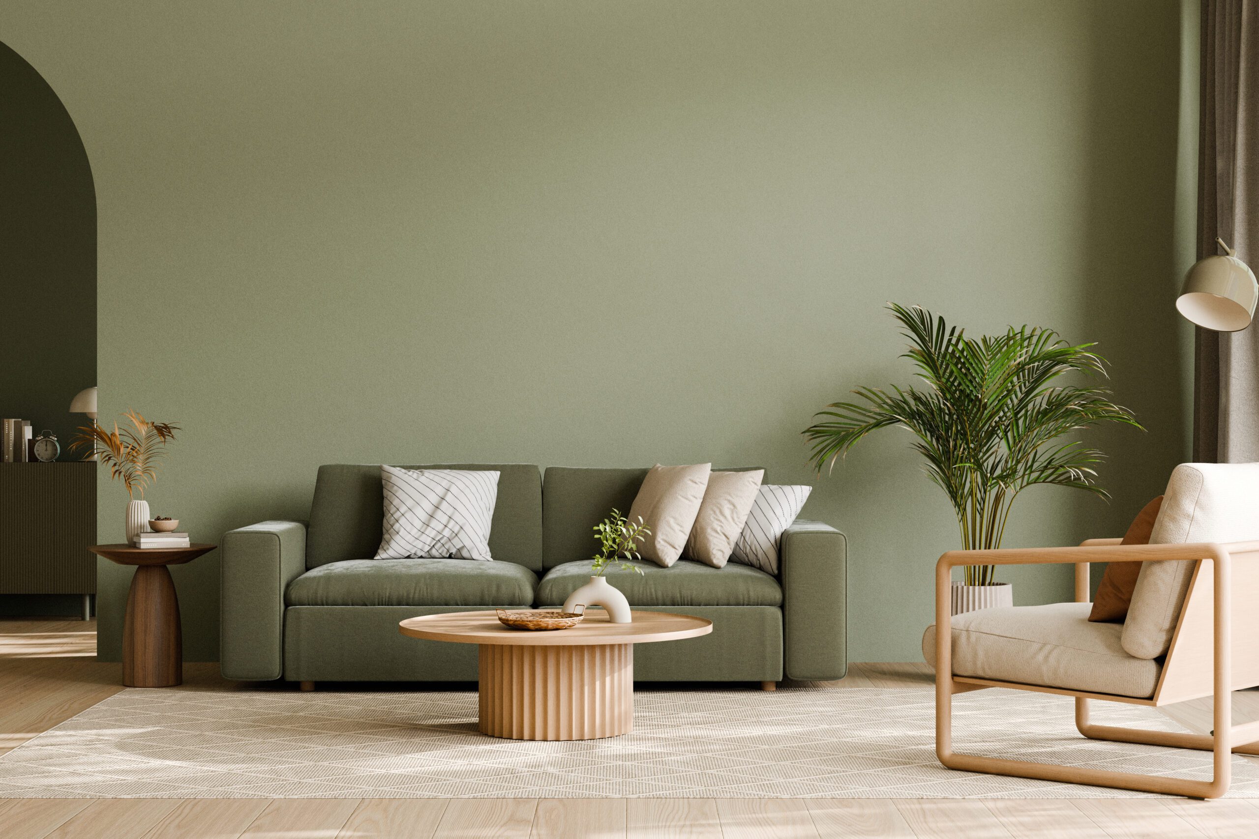 Modern living room with green sofa and potted plants.